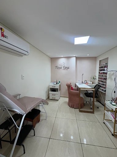 Sala de atendimento climatizada, com a maca, a poltrona rosa de manicure e o logo Nicole Cenci na parede